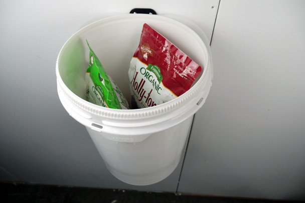 Bags of seeds in wall mounted bucket.