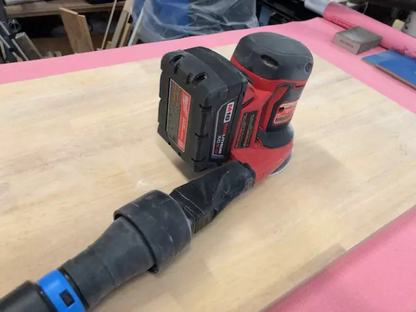 Quick Click adapter attached to a hand sander tool.