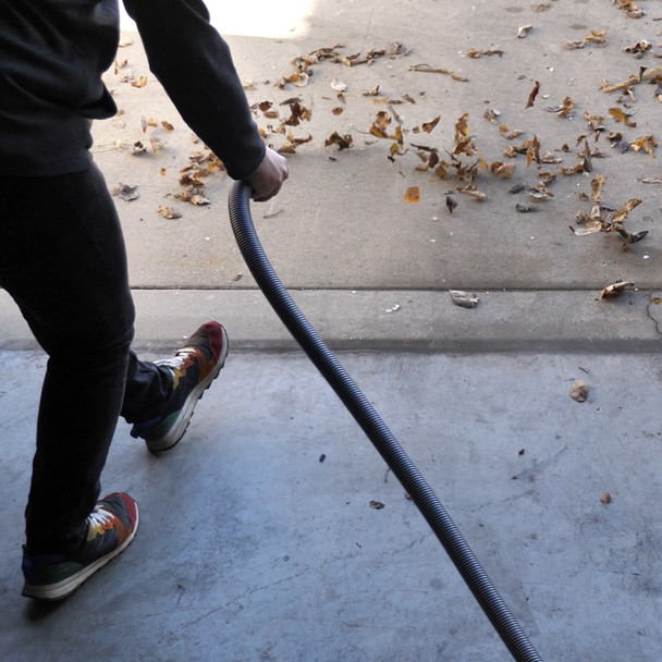 Hose being used to blow leaves out of garage.