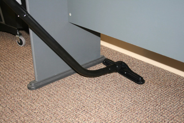 A floor brush attached to an S-Wand cleaning carpet under a desk.