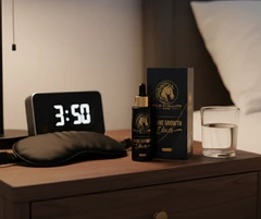 Mane Growth Elixir bottle and box on a bedside table at night