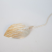 Side view. Luxurious fine silver with fine 24ct gold pendant.
Handcrafted using the age old Korean technique of Keum Boo, where 24ct gold is fused to the surface of the silver.
The metal is then embossed with specialised templates to create the desired layering of grass and Hakea nut imagery. 


 
