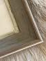 Photo of the grey wooden frame with silver detailing along the inside 