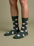 Jolly Santa Face Alpaca socks in dark green multi, on model