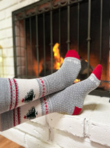 Warrior Alpaca Socks Rockwell Holiday Novelty Socks on feet by warm cozy fire.