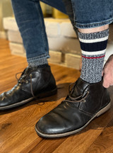 Model putting on Old School Athletic Stripe Alpaca Crew Socks with shoes.