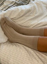 Cloud Nine Lounge Alpaca Crew Socks in Beige on Model relaxing in bed.