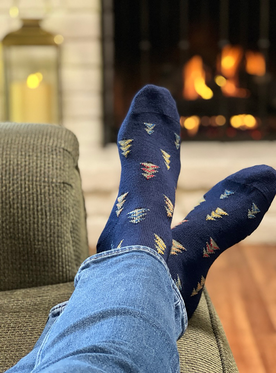 Holiday Christmas Tree Farm Baby Alpaca Socks on feet relaxing by a cozy warm fire.