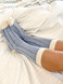 Colorblock Sleep Alpaca Crew Socks On feet relaxing in bed.