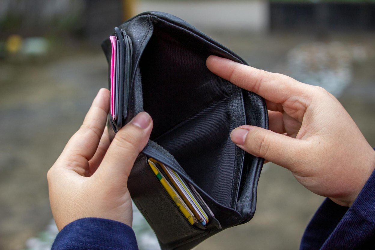 Hands Holding Open an Empty Black Wallet