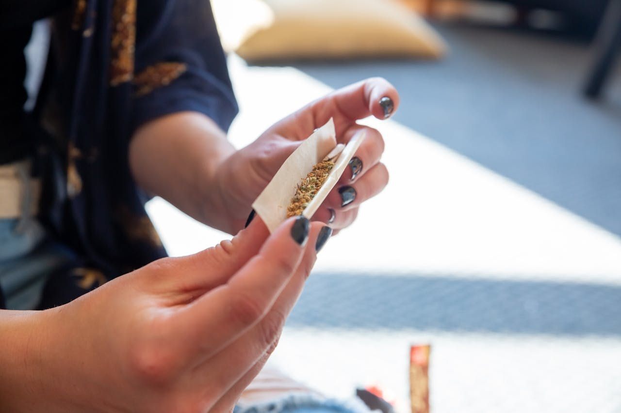 Hands rolling a cannabis joint