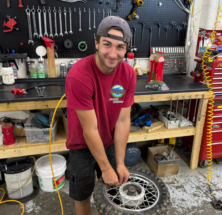 Mason Field mounting a tire on a dirt bike wheel