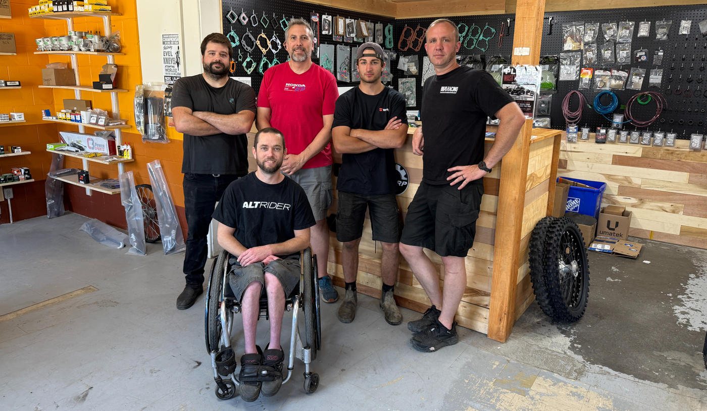 The TrueTech crew standing in the shop in front of a wall of engine gaskets