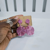 Hand holding contemporary cultural jewelry Fumi pink 3D printed symbolic statement earrings by dallas brand zuri perle