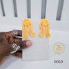 Hand holding contemporary cultural jewelry Iyun Okan Gold 3D printed symbolic statement earrings by dallas brand zuri perle Hand holding contemporary cultural jewelry Iyun Okan Gold 3D printed symbolic statement earrings by dallas brand zuri perle