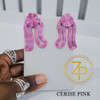 Hand holding contemporary cultural jewelry Iyun Okan Cerise Pink 3D printed symbolic statement earrings by dallas brand zuri perle b Hand holding contemporary cultural jewelry Iyun Okan Cerise Pink 3D printed symbolic statement earrings by dallas brand zuri perle b