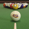 LSU Tigers cue ball positioned on green pool table felt in front of a racked set of billiard balls, featuring the purple and gold LSU Tiger logo with a pool cue lined up for the break.