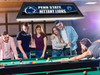 Lifestyle view of the Penn State Nittany Lions 42-inch hanging billiard table light installed above a pool table, demonstrating its appearance in a game room, billiard room, home bar, or Nittany Lions fan cave.