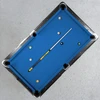 Overhead lifestyle view of the Wichita State Shockers Team Color Laser Etched Cue displayed diagonally across a blue-felt pool table, showcasing the collegiate billiard cue in a home game-room setting.