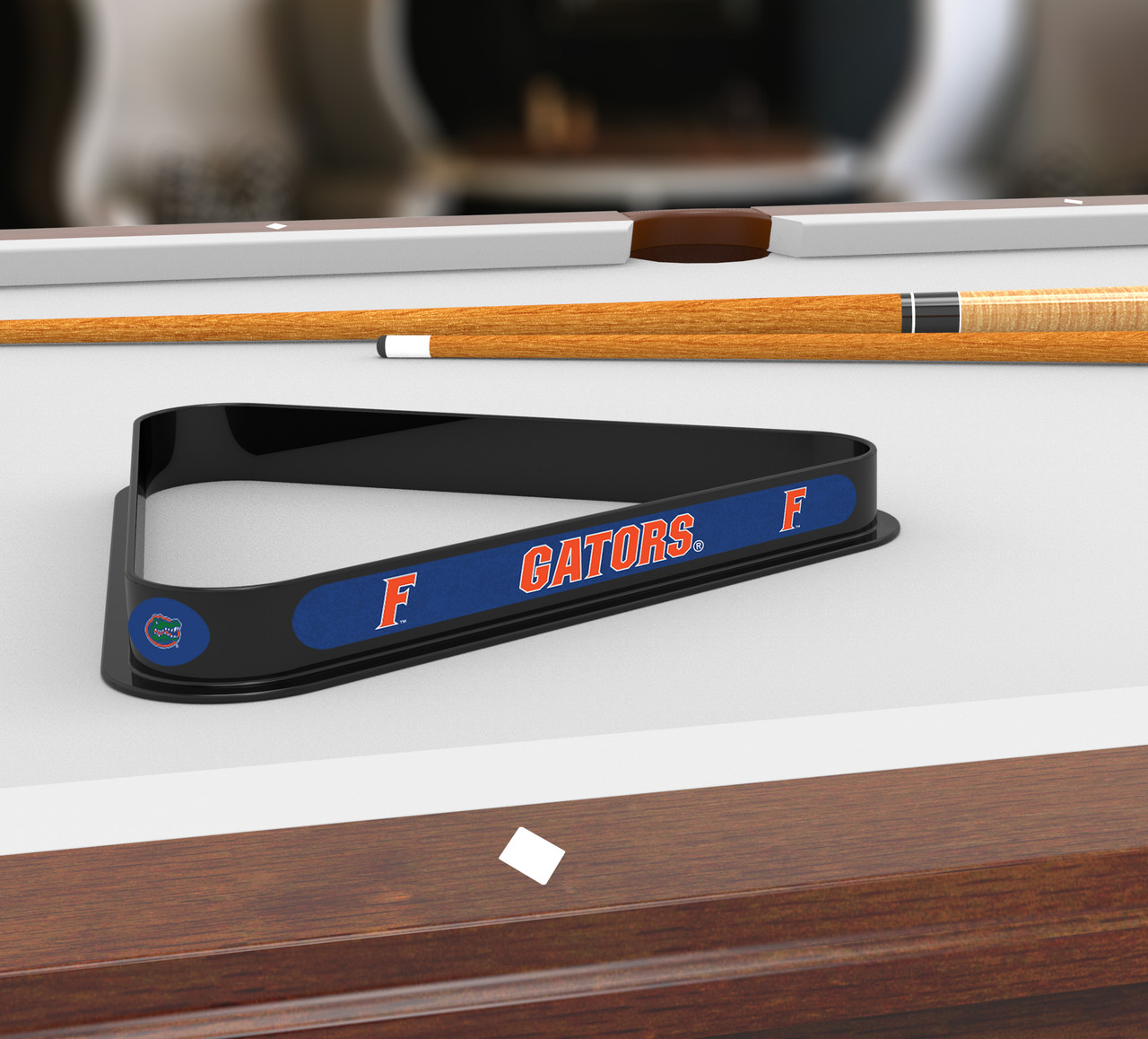 Florida Gators billiard triangle displayed on a pool table beneath billiard cues, showcasing the black frame and bold blue and orange team graphics in a game room setting.