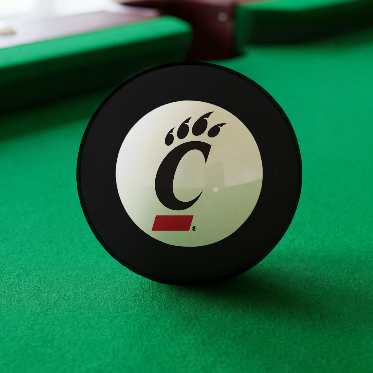 Cincinnati Bearcats Eight Ball displayed on green pool table felt, featuring the black and red Cincinnati C-Paw logo inside the white center circle of a classic black billiard Eight Ball.