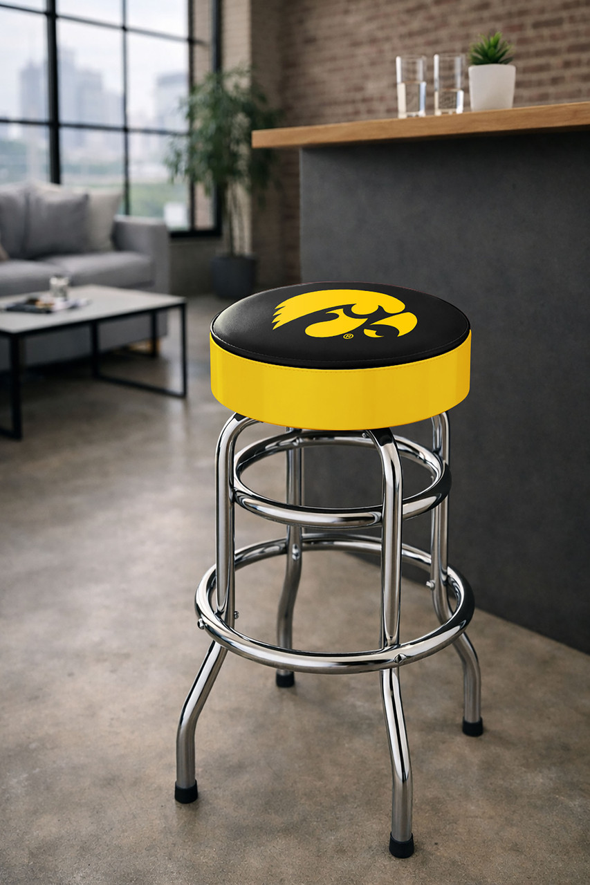 Iowa Hawkeyes 30" chrome bar stool displayed in a home entertainment setting, featuring a black and gold team logo seat with a polished chrome base. This college team stool is perfect for adding Iowa spirit to a fan cave, home bar, pool room, or game room.