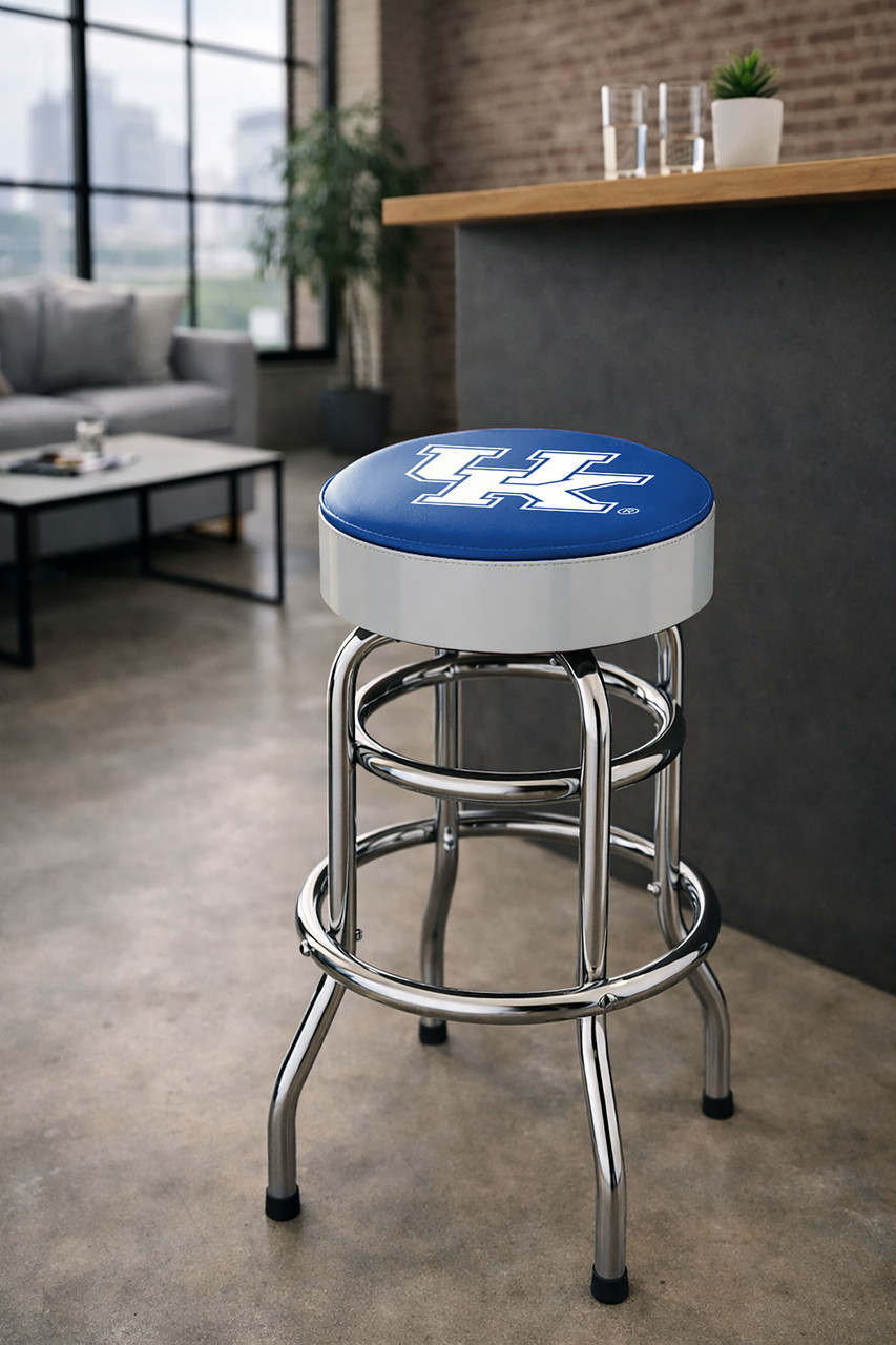 Kentucky Wildcats 30" chrome bar stool displayed in a home entertainment setting, featuring a blue and white team logo seat with a polished chrome base. This college team stool is perfect for adding Kentucky spirit to a fan cave, home bar, pool room, or game room.