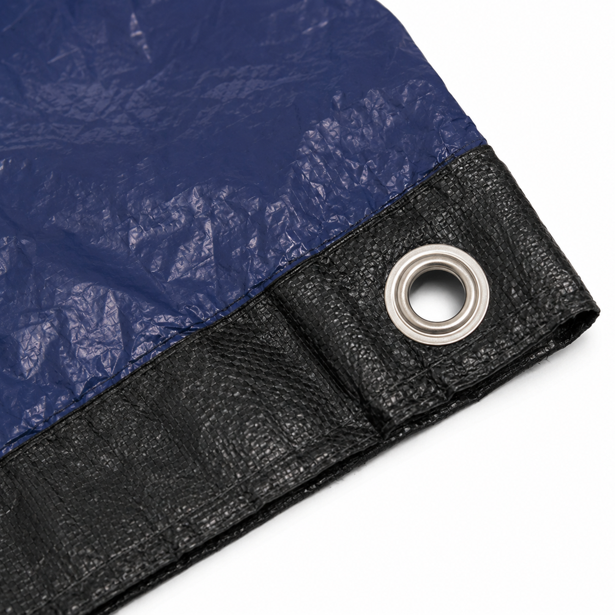 Close-up of the blue winter pool cover featuring a reinforced black edge and metal grommet designed for secure cable attachment around the pool.