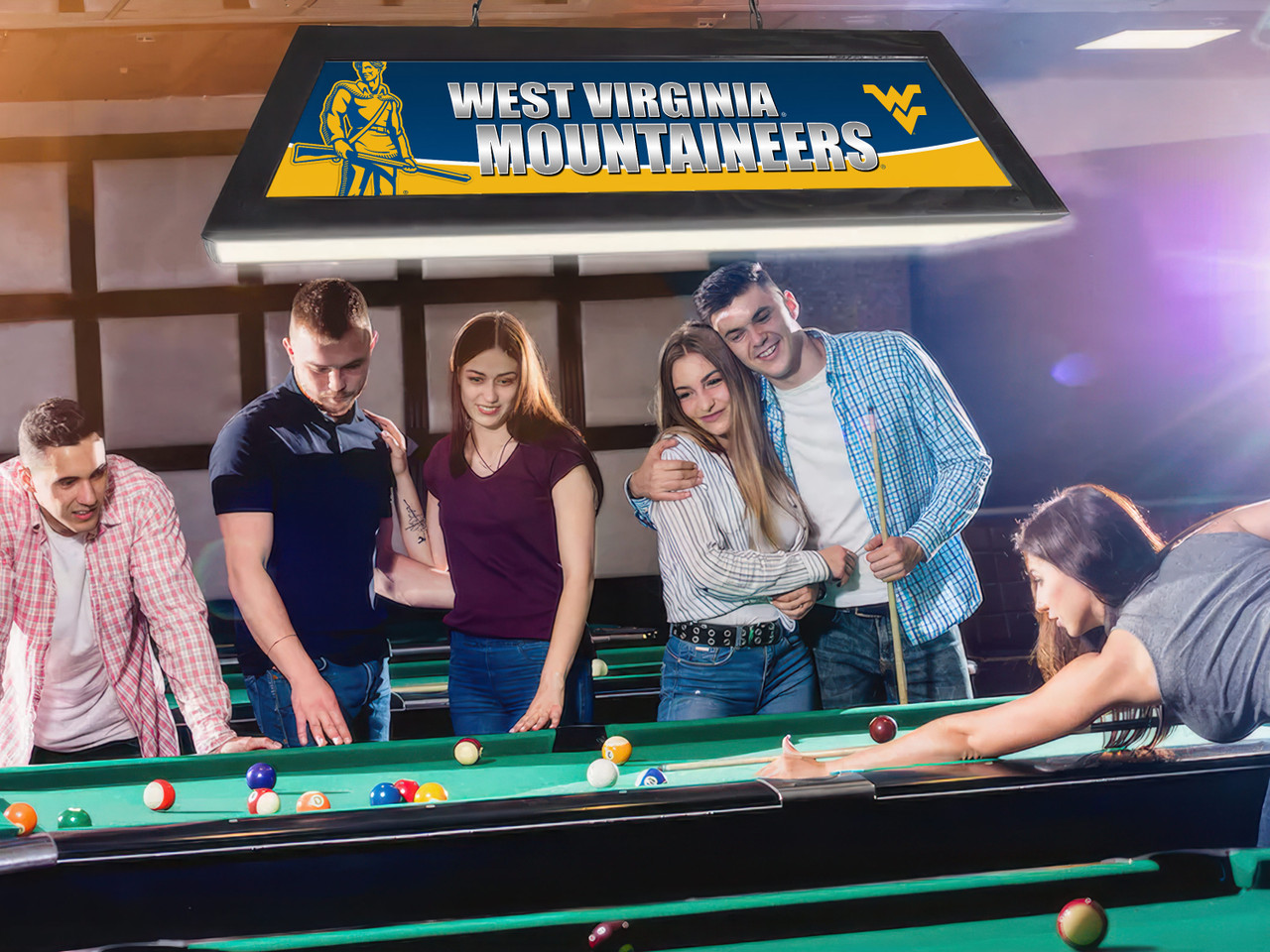 Lifestyle view of the West Virginia Mountaineers 42-inch hanging billiard table light installed above a pool table, demonstrating its appearance in a game room, billiard room, home bar, or WVU fan cave.