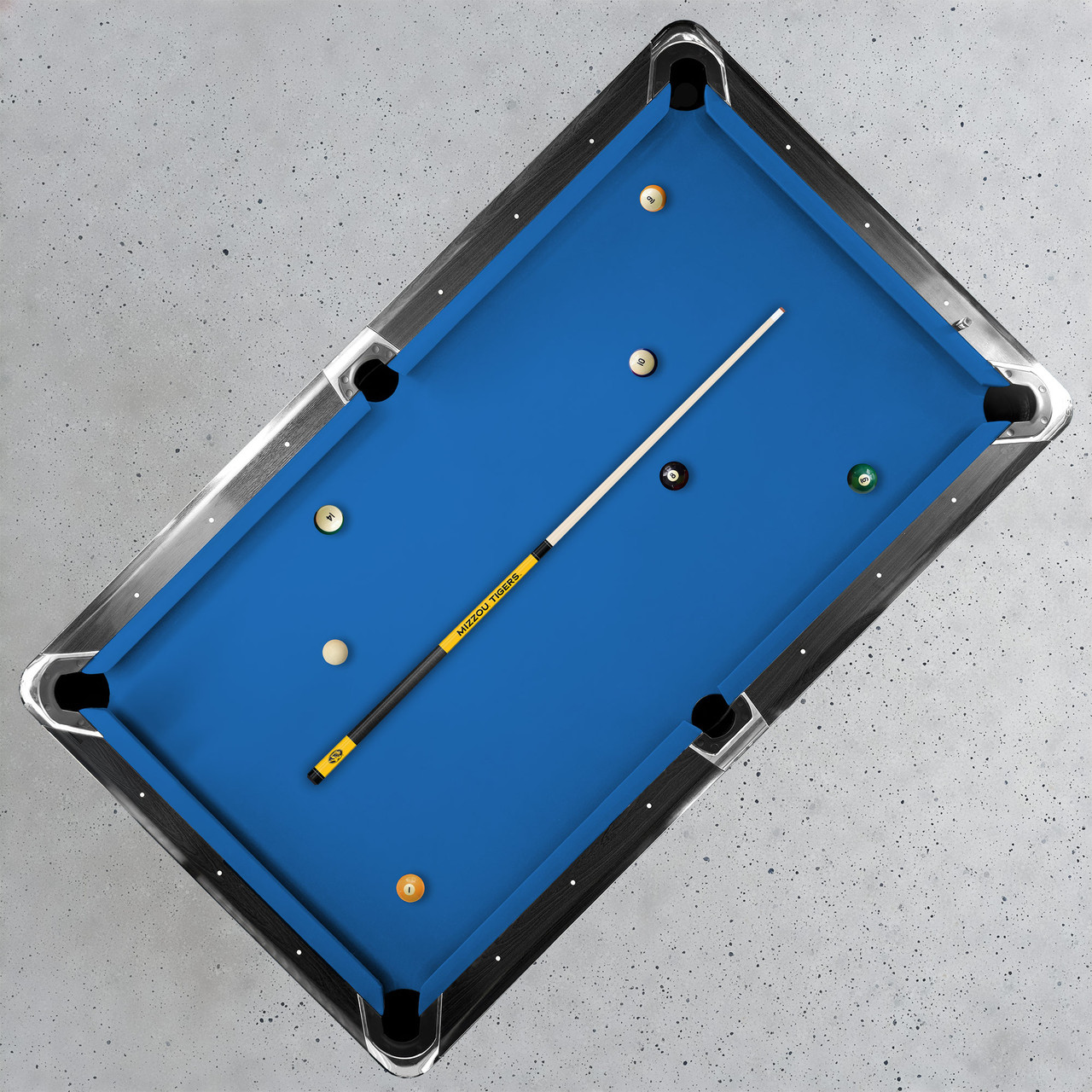 Missouri Tigers 19oz Team Color Laser Etched 58" Cue displayed diagonally across a blue-felt pool table, demonstrating its full playing length and Tigers game-room appearance.