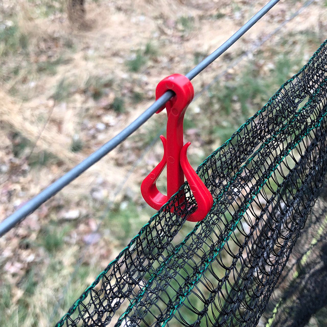 Red double hook net clip best used to hang side nets when storing the nets onto a lower wire during the winter months.