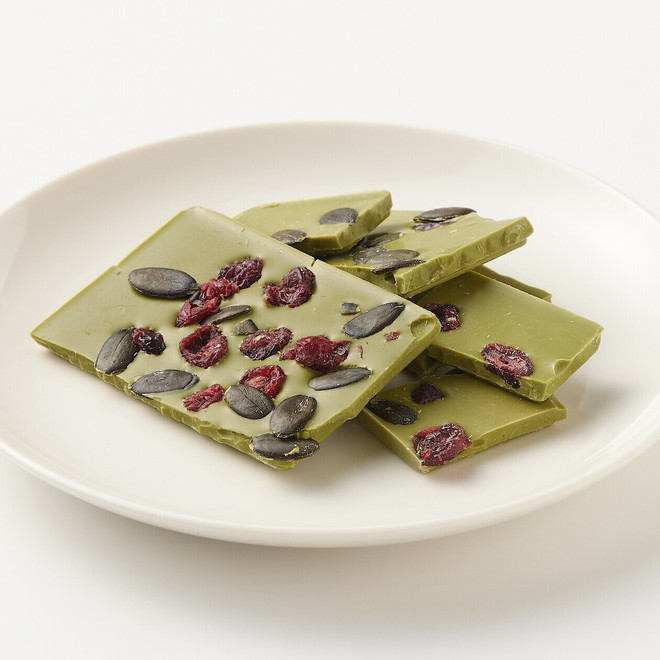 Chocolate blanco con arándanos rojos endulzados, semillas de calabaza y té verde matcha.