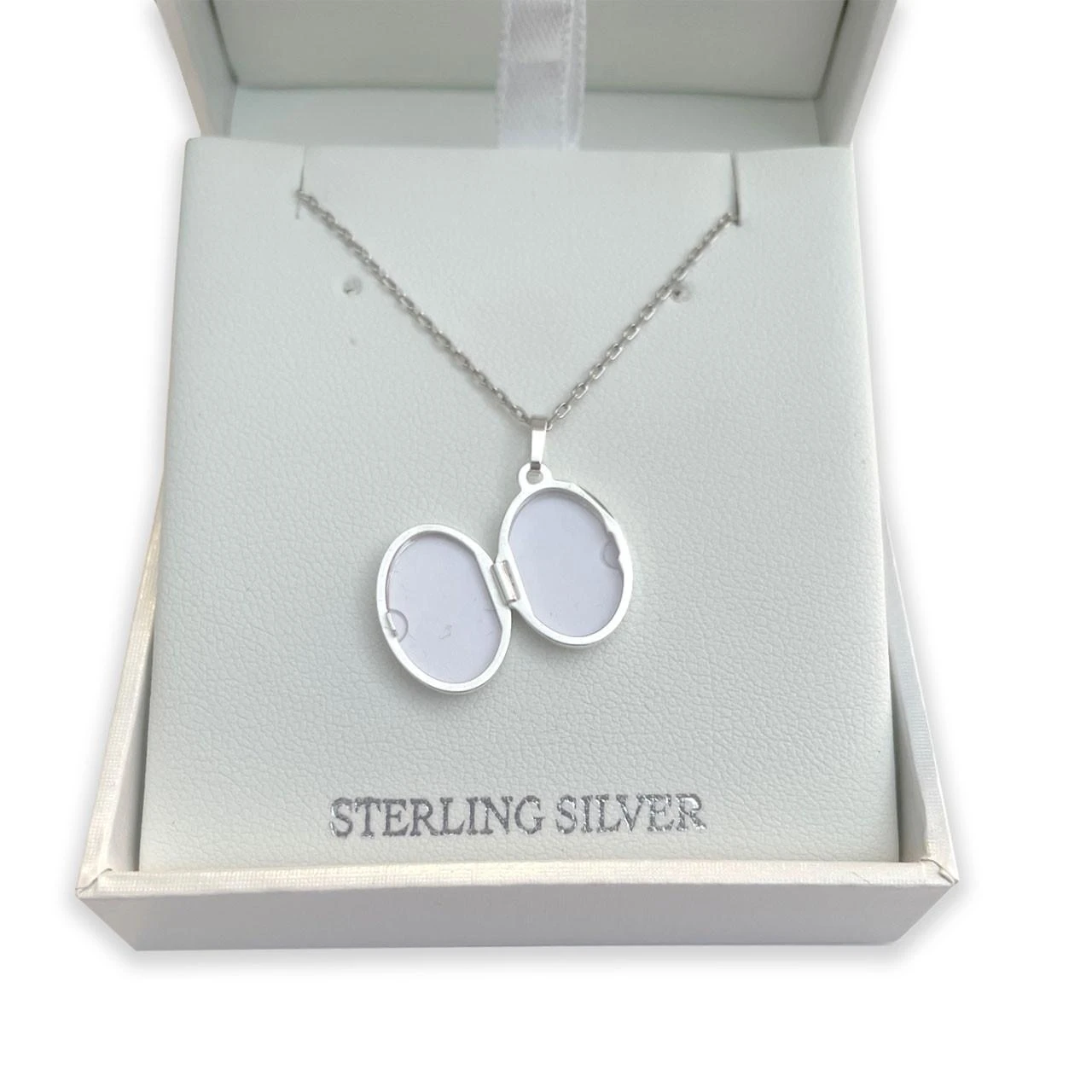 An opened Sterling Cross Locket Pendant in the box