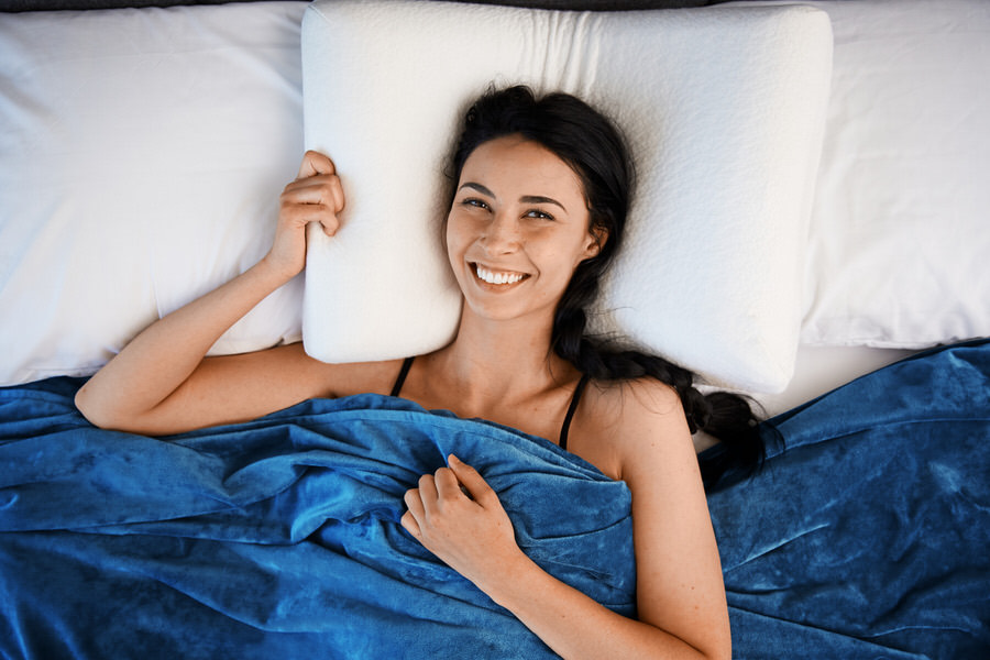Woman Smiling Under Moonbow Cooling Weighted Blanket with Blue Duvet Cover
