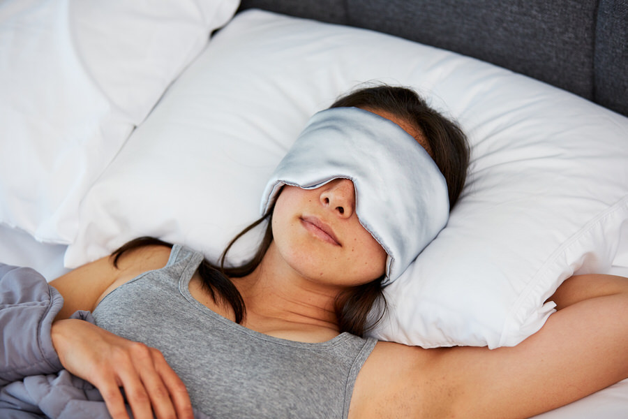 Woman sleeping with Moonbow Total Dark Satin Eye Mask