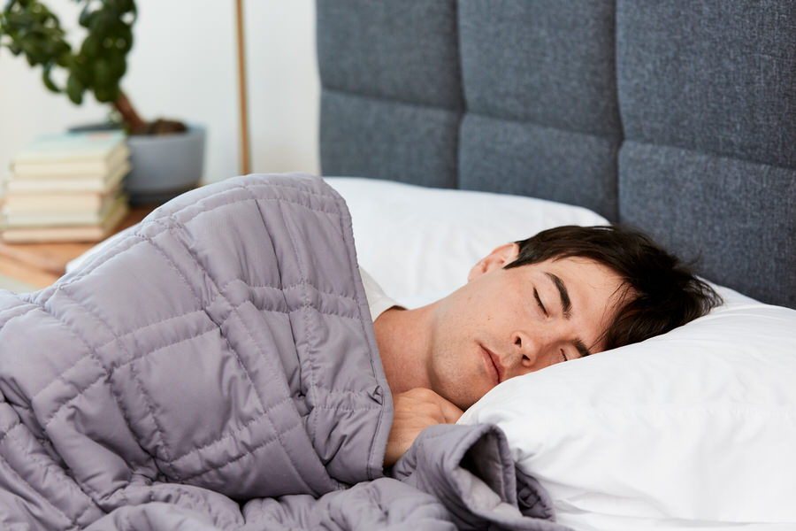 Man sleeping with Moonbow Cooling Weighted Blanket