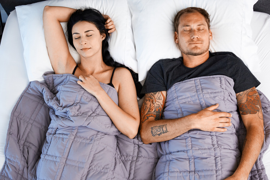 Couple Sleeping in bed under Moonbow Cooling Weighted Blanket