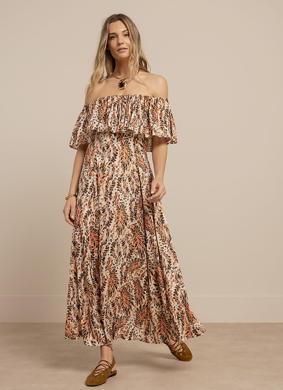 Close-up van een outfit met een donker jasje en een broek met grote stippenprint. Het contrast tussen de prints en kleuren laat zien hoe patronen een look speels en opvallend maken.