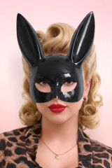 Portrait of a glamorous woman wearing a glossy black bunny mask and red lipstick.