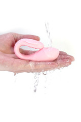Waterproof Pink Rechargeable Whisper Quiet Panty Vibrator with Remote Control held on hand for size comparison