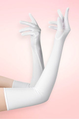 Long white spandex opera gloves in elbow length worn on both arms raised with fingers spread, against a pink background. 