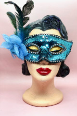 Blue Sequin Masquerade mask with flower and feather on a vintage mannequin head front view