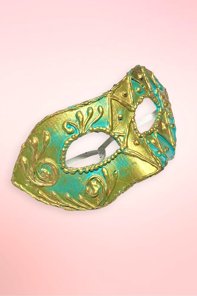 teal and gold Venetian masquerade mask angled left on pink background showing scrollwork floral side.