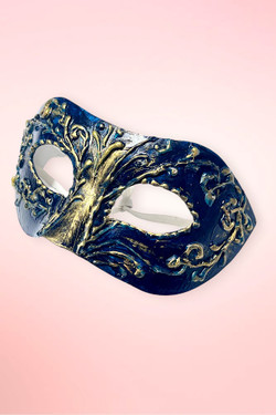 navy and gold Venetian masquerade mask angled right on pink background.