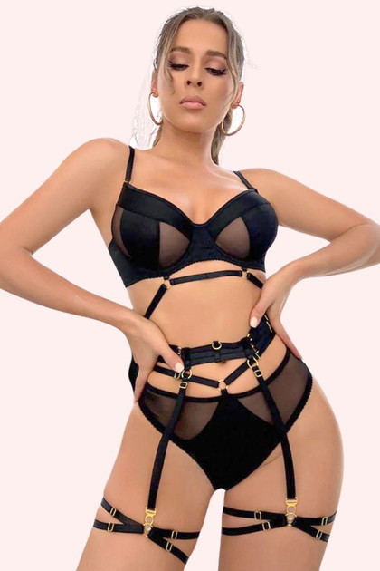 Olenna black mesh bralette with strappy garter belt thigs and mesh panty worn by a model with hands on her waist