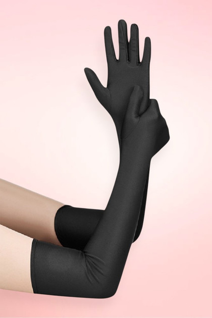 Long black spandex opera gloves in elbow length worn on both arms, one arm raised with open palm, against a pink background.