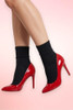 legs wearing black crew socks and  red pumps.