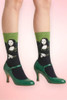 Mona Lisa art novelty crew socks worn with green Mary Jane heels.