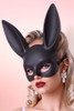 Glamorous blonde wearing a matte black bunny mask and red lipstick.