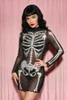 Woman with black wavy hair, bangs and red lipstick posing with a hand on her hip in a black sheer mesh skeleton print mini dress.